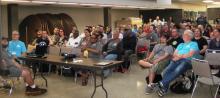 Mike Smith and Stuart Smith are in the front row watching as Kevin Smith presents the offcial 2018 video to all the Cleveland GiveCamp volunteers.