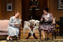 Actor Maggie Kettering (left, as Ruth) requests the assistance of Laurie Birmingham (right, as Madame Arcati) to exorcise her "demons"